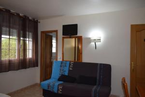 un salon avec un canapé bleu et une télévision dans l'établissement Hotel Restaurante Las Camelias, à Jarrio