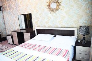 Un dormitorio con una cama grande y un espejo. en Luxury Palace Apartment, en Bishkek
