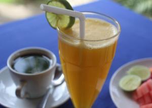 ein Glas Orangensaft neben einer Tasse Kaffee in der Unterkunft Dream Beach Cottages in Nusa Lembongan