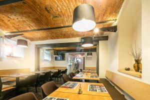 a restaurant with wooden ceilings and tables and chairs at Pytloun Self Check-in Hotel Liberec in Liberec