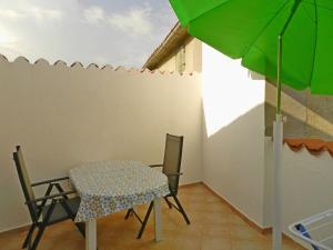 - une table et des chaises dans une pièce avec un parasol vert dans l'établissement Apartment Pokrajac, à Rovinjsko Selo