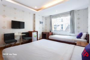 a hotel room with two beds and a tv at Mays Hotel- Ben Thanh Market in Ho Chi Minh City