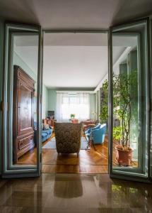 a living room with sliding glass doors and a chair at Gianduja B&B in Turin