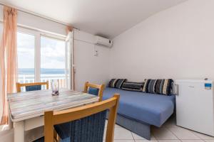 - une salle à manger avec une table et un canapé dans l'établissement Apartments Katarina, à Lokva Rogoznica