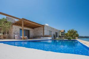 a villa with a swimming pool and a house at Niova Villa in Alykes