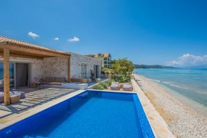 a villa with a swimming pool next to the ocean at Niova Villa in Alykes