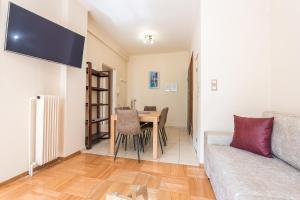 ein Wohnzimmer mit einem Tisch und einem Sofa in der Unterkunft Victoria Familia Apartments in Athen