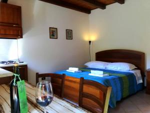 Schlafzimmer mit einem Bett und einem Tisch mit einem Glas Wein in der Unterkunft Agriturismo Radovic in Aurisina