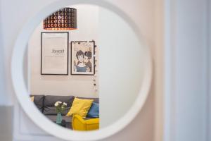 uma sala de estar com um sofá amarelo e um espelho em CYC Apartment em Budapeste