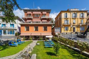 a building with blue lounge chairs in front of it at Hotel Villa Maria in Sanremo
