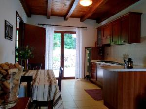 eine Küche mit einem Tisch und eine Küche mit einem Fenster in der Unterkunft Agriturismo Radovic in Aurisina