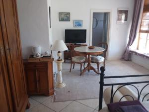 a living room with a table and a television at Le Patronage in Bazoges-en-Pareds