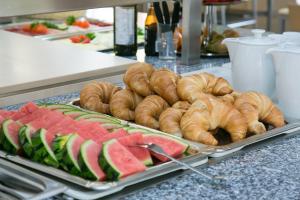 ein Buffet mit Gebäck und Wassermelonen auf dem Tisch in der Unterkunft Jugendhaus St. Kilian in Miltenberg