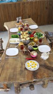 a wooden table with plates of food on it at Azure Wellness Retreat in Turgutreis