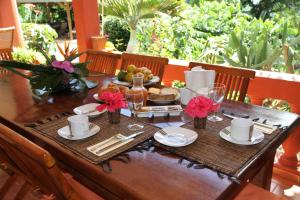 a wooden table with food and flowers on it at Villa Maora in Kangani