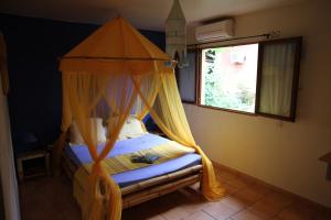 a bedroom with a bed with a canopy at Villa Maora in Kangani