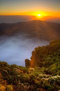a sunrise over a foggy valley with the sun setting on a mountain at Bandama Golf Hotel by Airnest in Santa Brígida