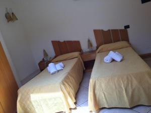 2 letti in camera d'albergo con asciugamani di Agriturismo Terre Delle Monache a Pontecagnano