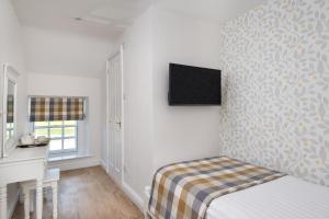 a bedroom with a white bed and white walls at The King's Head in Legburthwaite