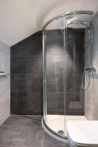 a shower with a glass door in a bathroom at The King's Head in Thirlmere