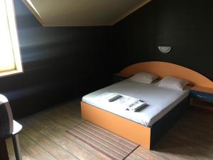 a bedroom with a bed with an orange headboard at Europe Dunav Apartment in Vidin