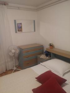 a bedroom with a bed and a dresser and a desk at House Krk in Krk