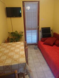 a bedroom with a bed and a table and a television at House Krk in Krk