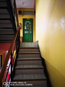 a stairway leading up to a green door at A's Azotea de Bohol in Tagbilaran City