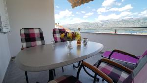 a table with a vase of flowers on a balcony at Apartment Ana in Vinjerac