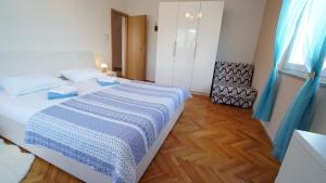 a bedroom with a bed with a blue and white blanket at Apartment Ana in Vinjerac