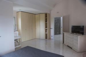 a living room with a flat screen tv on a dresser at Vdl Luxury Villa in Floridia