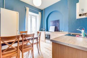 a kitchen with blue walls and a table and chairs at STN Apartments by the Hermitage in Saint Petersburg