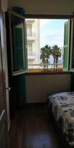 a bedroom with a window with a view of a building at Nice Seaview Free Parking 4.Pers in Nice