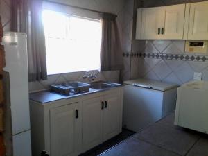 a small kitchen with a sink and a window at Stokkiesdraai Holiday Apartments in St Lucia