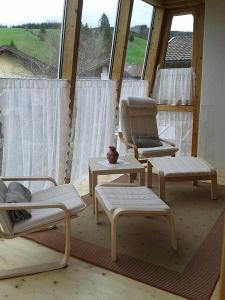 Zimmer mit 3 Stühlen, einem Stuhl und einem Fenster in der Unterkunft Haus Aria in Achenkirch