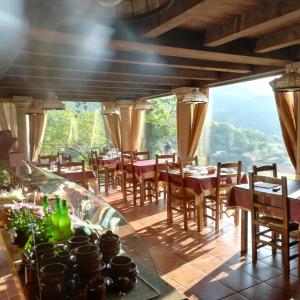 ein Restaurant mit Tischen und Stühlen und einem großen Fenster in der Unterkunft Caseria la Infiesta in Caleao