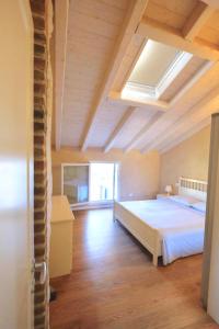 a bedroom with a large bed and a skylight at Chez Alberto in Mirano