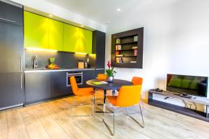 a kitchen with a table and chairs and a television at Cosmo Apartments Passeig de Gràcia in Barcelona