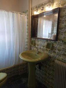 a bathroom with a green sink and a mirror at Glaros in Skaramangás