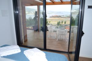 a bedroom with a balcony with a table and chairs at Desconectate in Aldán