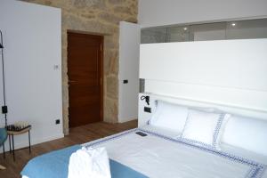a bedroom with a white bed and a brown door at Desconectate in Aldán