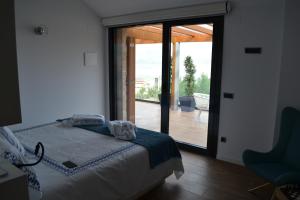 a bedroom with a bed and a sliding glass door at Desconectate in Aldán