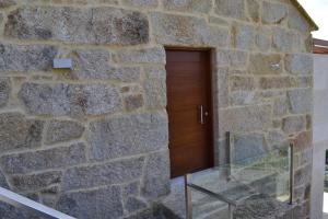 a stone building with a wooden door in it at Desconectate in Aldán