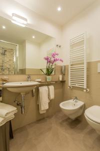 a bathroom with a sink and a toilet and a mirror at Hotel Adelphi in Riccione