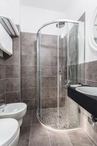 een badkamer met een douche, een toilet en een wastafel bij Hotel Eugenio in Cesenatico