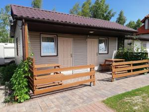 a small house with benches in front of it at Camping Mauritius in Mielno