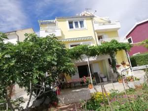 a yellow house with a table in front of it at Apartmani Marija in Primošten