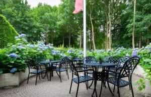 un grupo de mesas y sillas en un jardín en Bastion Hotel Heerlen, en Heerlen