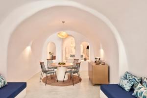 uma sala de jantar e sala de estar com mesa e cadeiras em Limestone em Fira