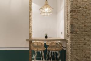 a kitchen with a table and two stools at Petit Palace Canalejas Sevilla in Seville